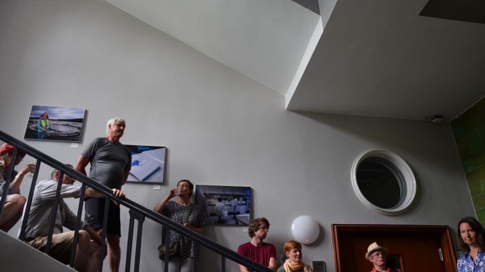 G&auml;ste besichtigen eine Fotoausstellung im IGB-Flur