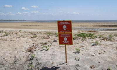 View of the former Kakhovka reservoir bottom near the village of Novovorontsovka after the drainage. The sign says: "Swimming is forbidden!" And "Attention! Mines!".
