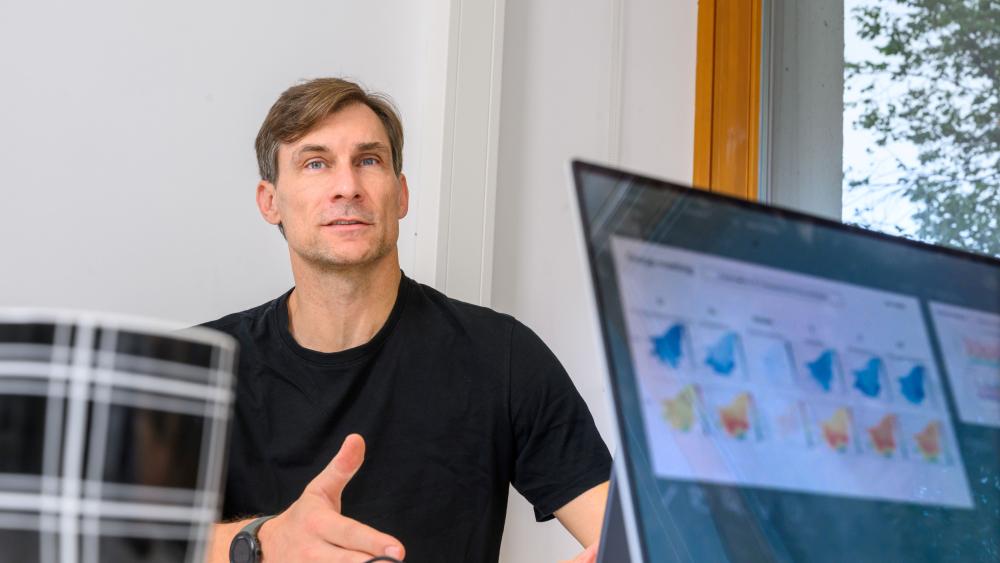 Christian Birkel in seinem B&uuml;ro. Im Vordergrund steht ein Laptop.