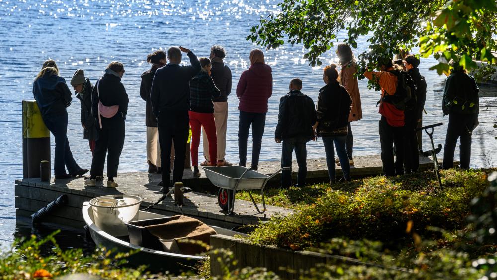 Eine Besuchergruppe steht am IGB-Ufer und blickt auf den M&uuml;ggelsee
