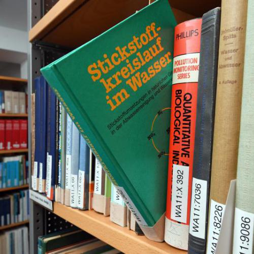 View into the corridor of the IGB library. In the foreground, shelves with monographs.