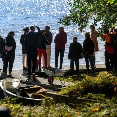 Eine Besuchergruppe steht am IGB-Ufer und blickt auf den M&uuml;ggelsee