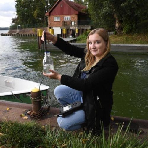 Eine junge Auszubildende nimmt eine Wasserprobe aus dem Müggelsee: Nur eine von vielen möglichen Tätigkeiten am IGB.
